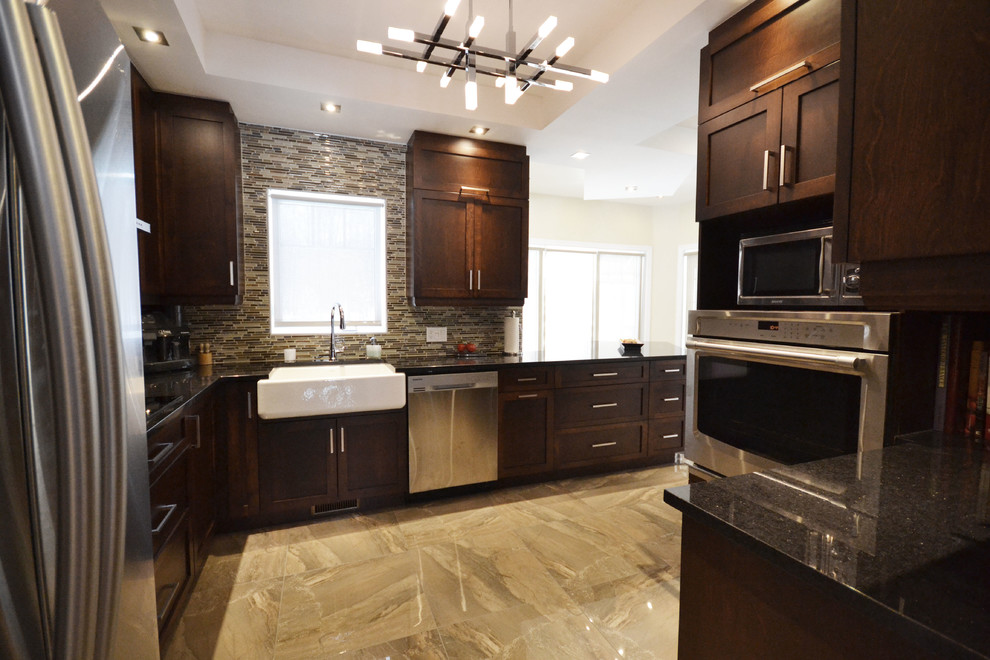 This is an example of a mid-sized transitional l-shaped eat-in kitchen in Ottawa with a farmhouse sink, shaker cabinets, dark wood cabinets, quartz benchtops, multi-coloured splashback, matchstick tile splashback, stainless steel appliances, marble floors, a peninsula and brown floor.