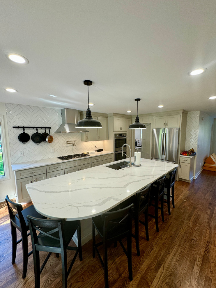 Mid-sized transitional l-shaped medium tone wood floor, brown floor and wallpaper ceiling eat-in kitchen photo in Atlanta with an undermount sink, shaker cabinets, white cabinets, granite countertops, white backsplash, stainless steel appliances, an island and white countertops