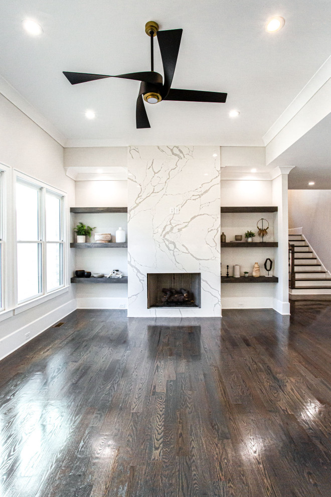 Großes, Offenes Klassisches Wohnzimmer mit grauer Wandfarbe, braunem Holzboden, Kamin, Kaminumrandung aus Stein, TV-Wand, braunem Boden und eingelassener Decke in Atlanta
