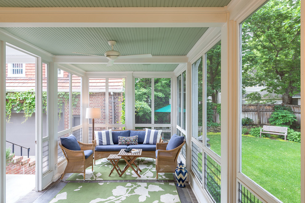 This is an example of a mid-sized traditional backyard screened-in verandah in Minneapolis with brick pavers and a roof extension.