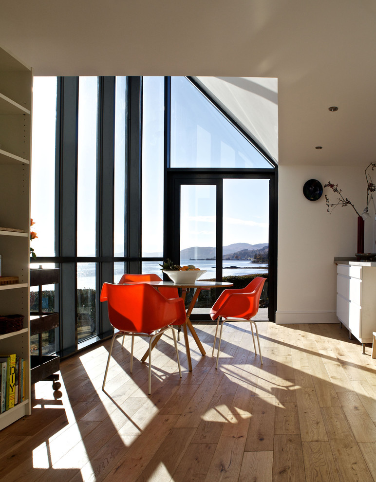 Coastal dining room in Edinburgh with white walls and light hardwood flooring.