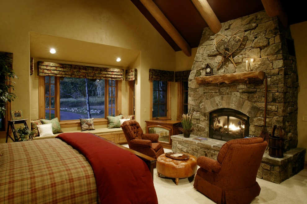 Design ideas for a country bedroom in Denver with yellow walls, carpet, a standard fireplace and a stone fireplace surround.