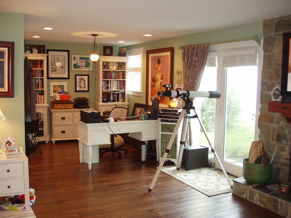 Photo of a small traditional study room in Baltimore with medium hardwood floors, a standard fireplace, a stone fireplace surround, a freestanding desk and green walls.