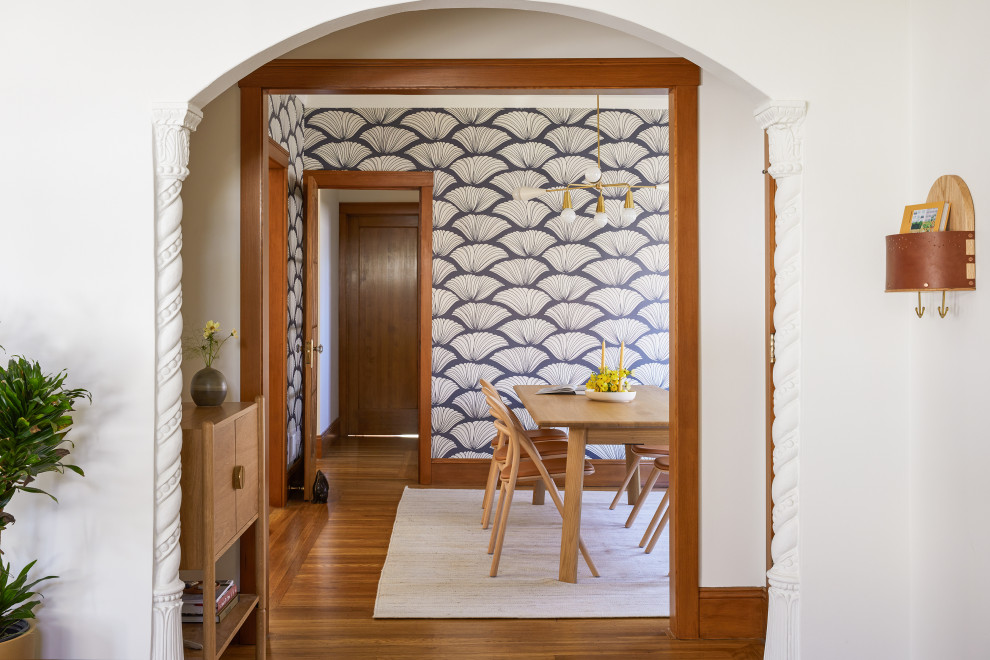 サンフランシスコにあるお手頃価格の小さなヴィクトリアン調のおしゃれな玄関ロビー (白い壁、無垢フローリング、木目調のドア、茶色い床) の写真