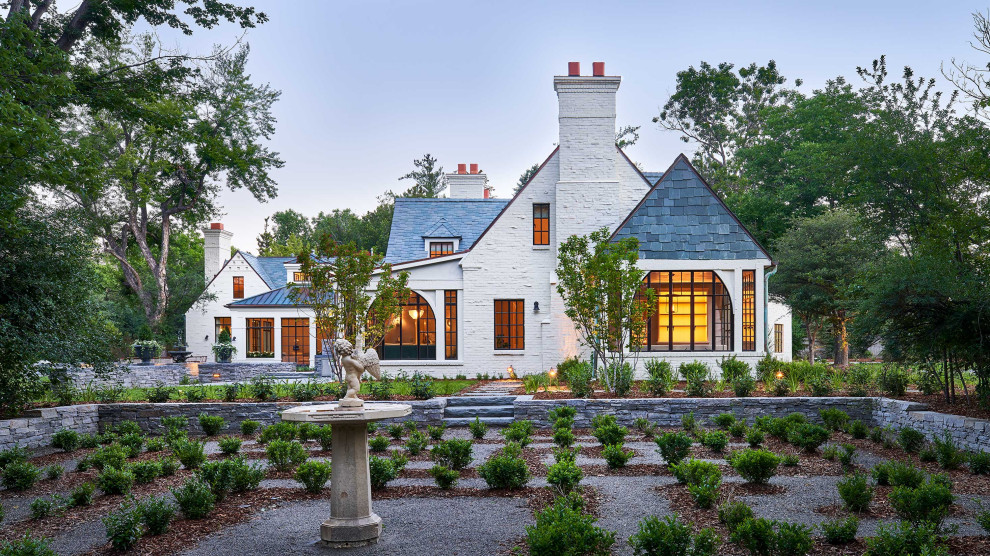 This is an example of a large transitional two-storey brick white house exterior in Denver with a grey roof.