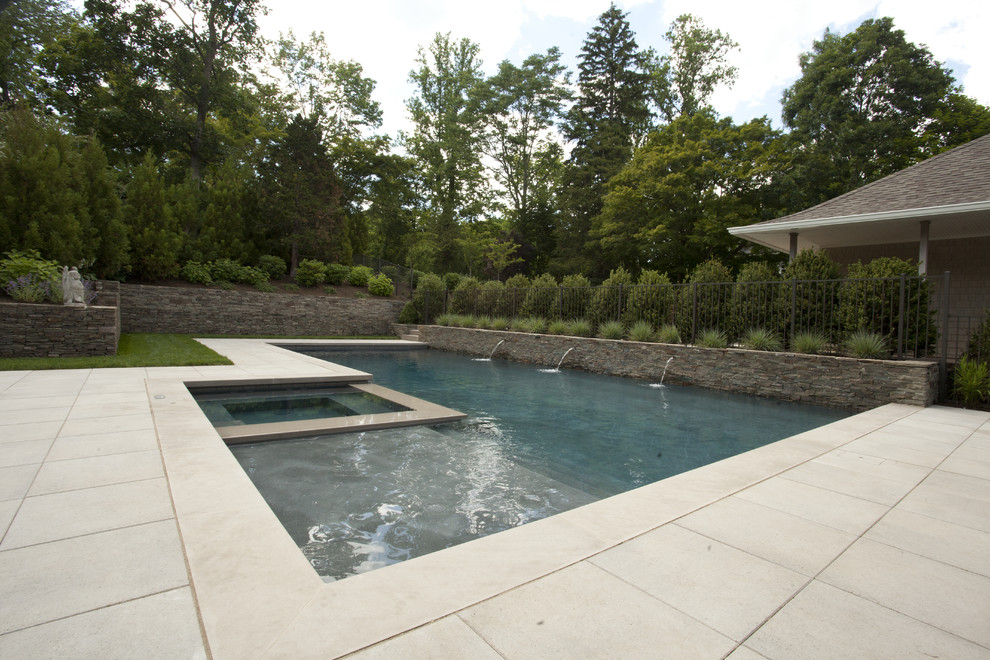 Inspiration for a mid-sized modern backyard l-shaped lap pool in New York with a hot tub and concrete pavers.
