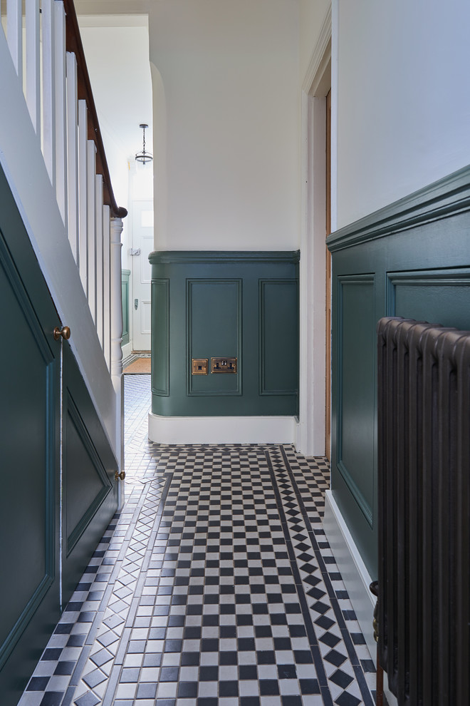 This is an example of a large hallway in London with white walls and ceramic floors.