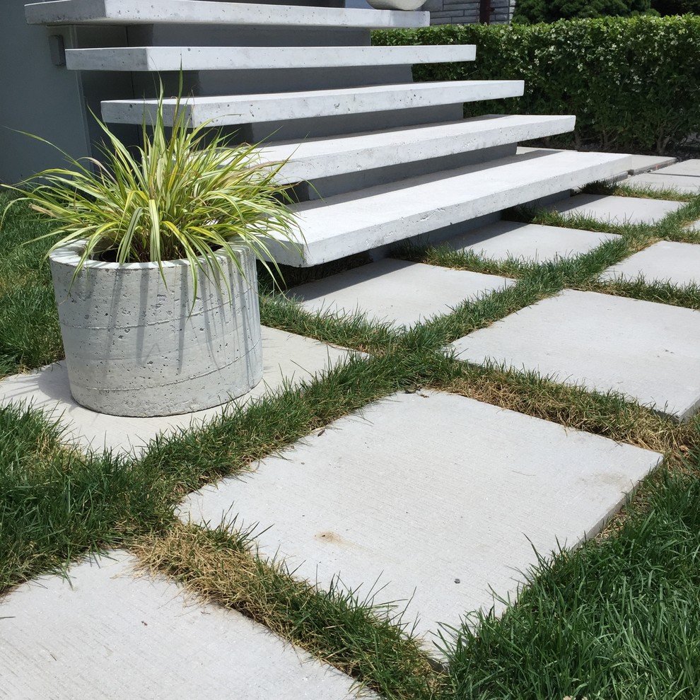 Photo of a mid-sized modern front yard partial sun garden in Toronto with concrete pavers.