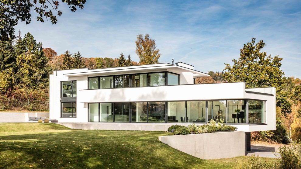 Inspiration for a large contemporary two-storey stucco white exterior in Stuttgart with a flat roof.