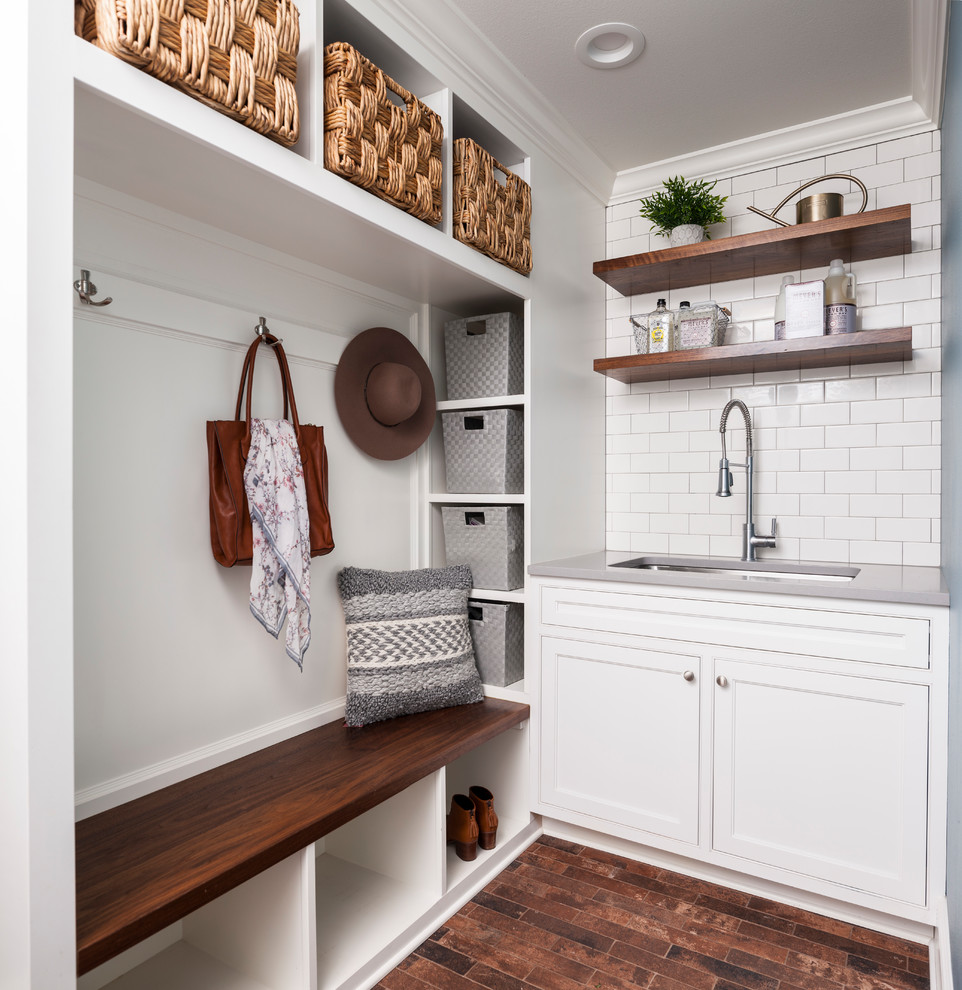 Inspiration for a small country single-wall utility room in Seattle with an undermount sink, shaker cabinets, white cabinets, white walls, brown floor, solid surface benchtops, medium hardwood floors and grey benchtop.