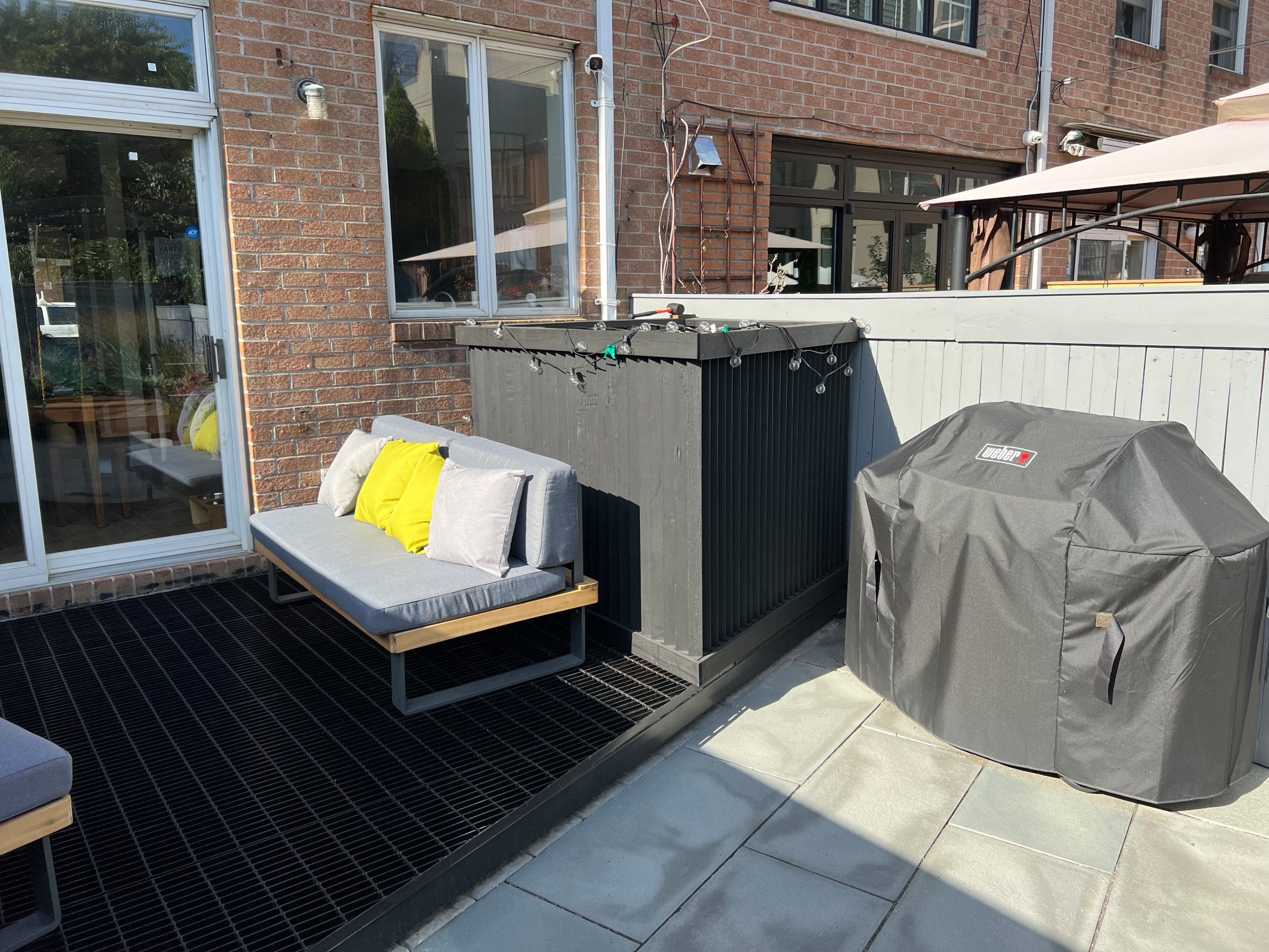 Paved patio with metal grating garden