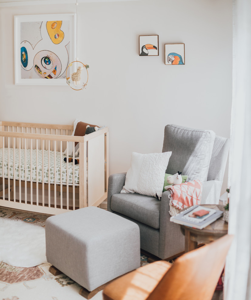 Nursery - mid-sized eclectic gender-neutral medium tone wood floor nursery idea in Los Angeles with white walls