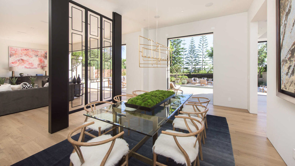 Contemporary open plan dining in Los Angeles with white walls, light hardwood floors and beige floor.