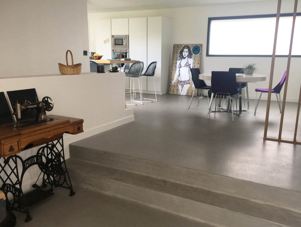 Diseño de salón abierto contemporáneo de tamaño medio con suelo de cemento y suelo gris