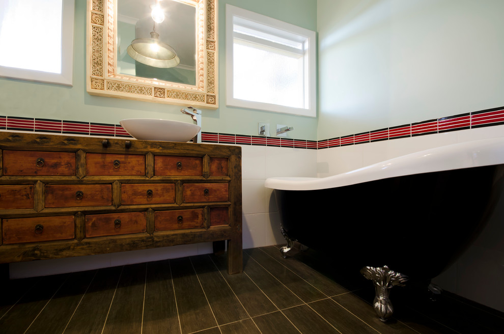 Small eclectic master bathroom in Melbourne with a vessel sink, furniture-like cabinets, medium wood cabinets, wood benchtops, a claw-foot tub, an alcove shower, a one-piece toilet, red tile, green walls, ceramic floors, ceramic tile, brown floor and a hinged shower door.