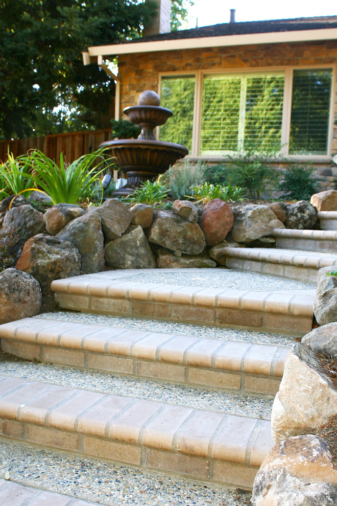 Inspiration for a large asian front yard partial sun xeriscape in San Francisco with a retaining wall and brick pavers.