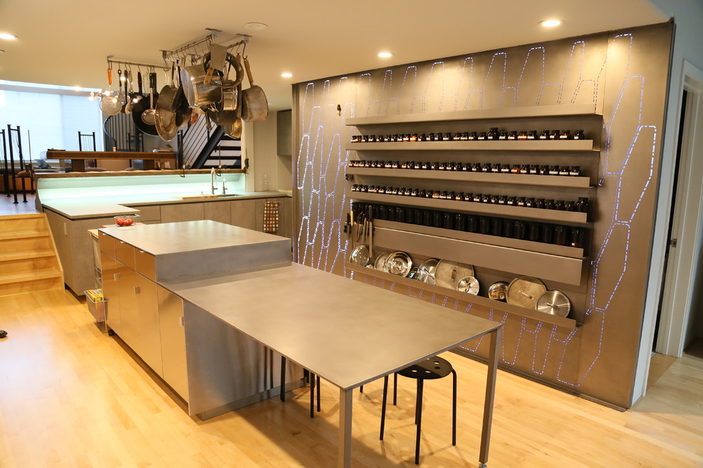 Contemporary l-shaped eat-in kitchen in San Francisco with an undermount sink, flat-panel cabinets, grey cabinets, zinc benchtops, grey splashback, metal splashback, panelled appliances, light hardwood floors, with island, beige floor and grey benchtop.