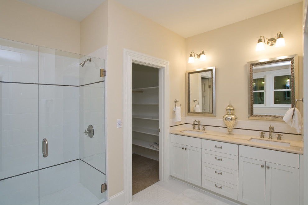 Inspiration for a mid-sized traditional master bathroom in Portland with an undermount sink, recessed-panel cabinets, white cabinets, marble benchtops, a claw-foot tub, an alcove shower, white tile, porcelain tile, beige walls and porcelain floors.