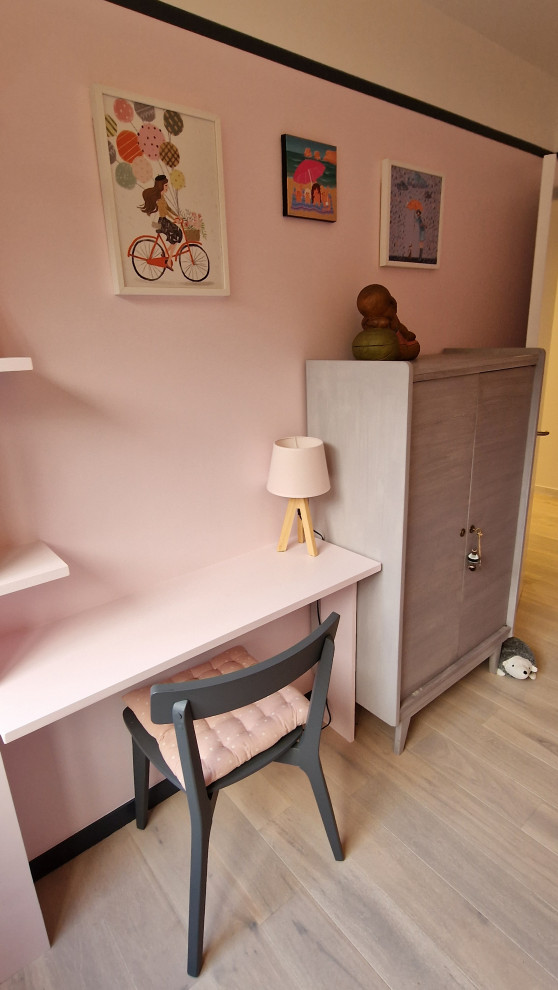 Ejemplo de habitación de niña de 4 a 10 años tradicional renovada de tamaño medio con escritorio, paredes rosas, suelo laminado y suelo beige
