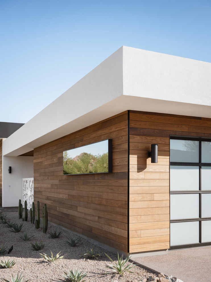 Réalisation d'une façade de maison blanche minimaliste en bois de plain-pied avec un toit plat.