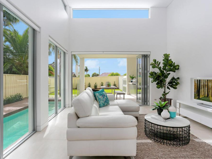 This is an example of a mid-sized contemporary open concept family room in Sydney with white walls, concrete floors, no fireplace and a freestanding tv.