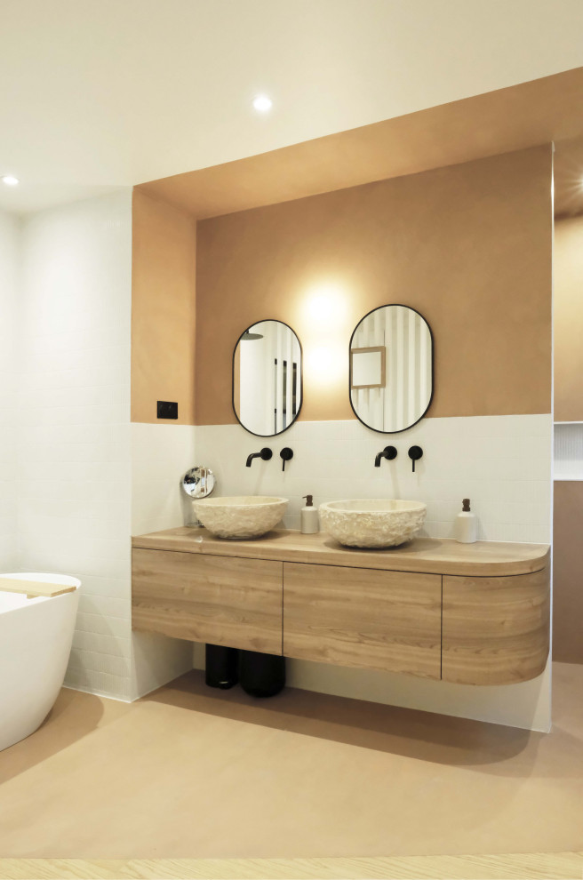 Стильный дизайн: большая главная ванная комната в современном стиле с накладной ванной, душем без бортиков, оранжевыми стенами, бетонным полом, настольной раковиной, столешницей из дерева, оранжевым полом, тумбой под две раковины и подвесной тумбой - последний тренд