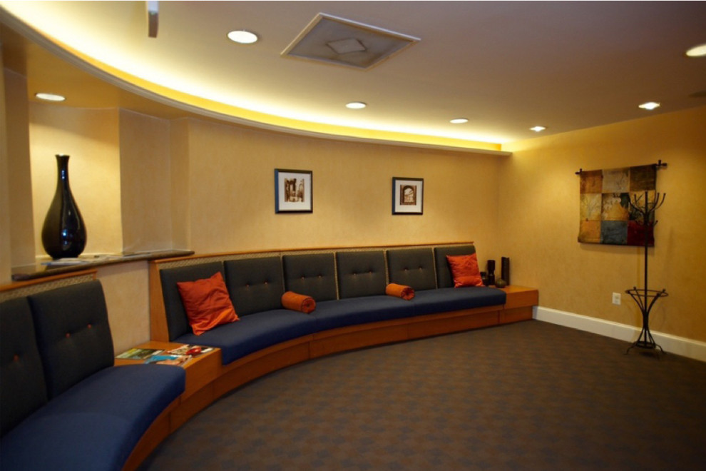 This is an example of a modern home theatre in DC Metro with orange walls, carpet and multi-coloured floor.