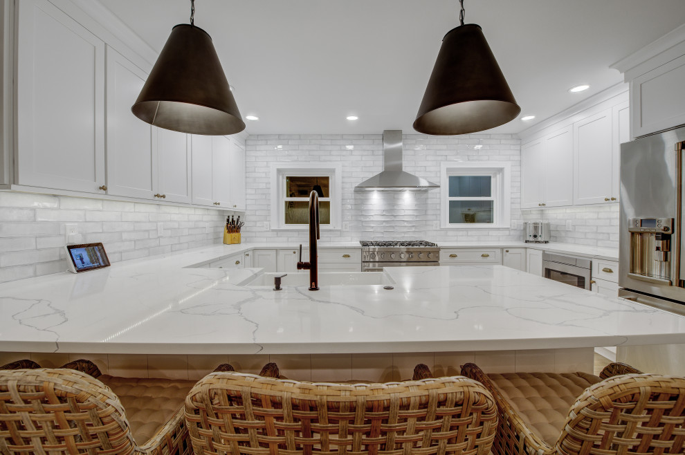 Eat-in kitchen - mid-sized transitional u-shaped light wood floor and beige floor eat-in kitchen idea in Philadelphia with a farmhouse sink, shaker cabinets, white cabinets, quartz countertops, white backsplash, subway tile backsplash, no island and white countertops