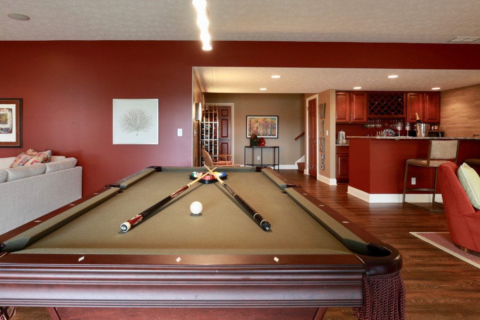 Photo of a large contemporary open plan games room in Cleveland with a home bar, red walls, medium hardwood flooring and brown floors.