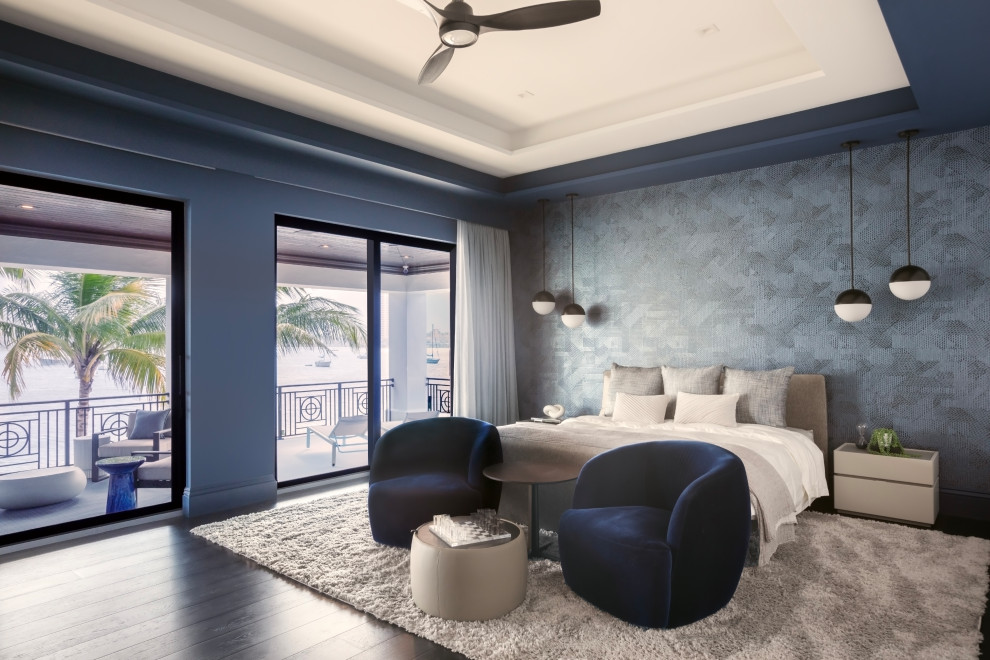 Example of a transitional dark wood floor, brown floor, tray ceiling and wallpaper bedroom design with gray walls
