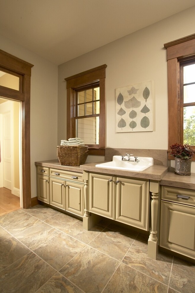 Photo of a large traditional dedicated laundry room in Cedar Rapids with a drop-in sink, beige cabinets, raised-panel cabinets, laminate benchtops, beige walls, ceramic floors, beige floor and beige benchtop.