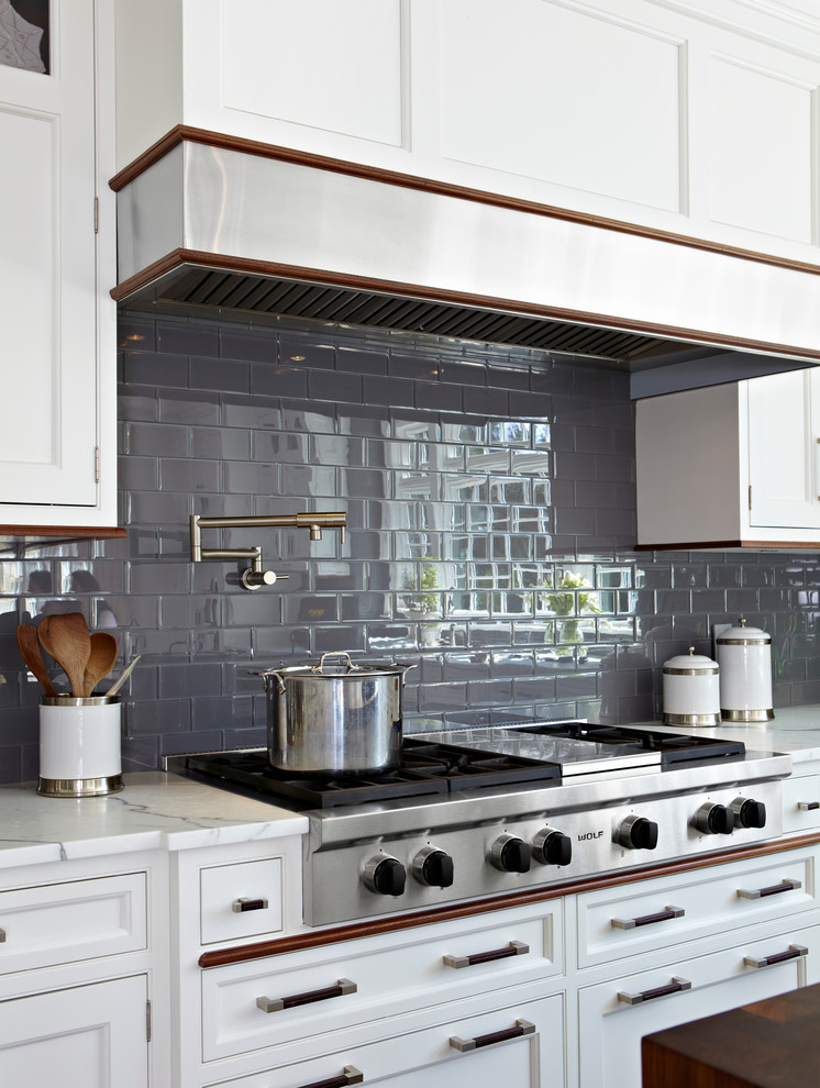 Inspiration for a large transitional l-shaped eat-in kitchen in New York with an undermount sink, shaker cabinets, white cabinets, marble benchtops, grey splashback, subway tile splashback, stainless steel appliances, dark hardwood floors, with island and brown floor.