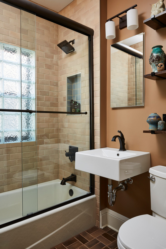 Photo of a small arts and crafts 3/4 bathroom in Minneapolis with an alcove tub, a shower/bathtub combo, a two-piece toilet, beige tile, ceramic tile, brown walls, ceramic floors, a wall-mount sink, brown floor, a sliding shower screen, a single vanity and a floating vanity.