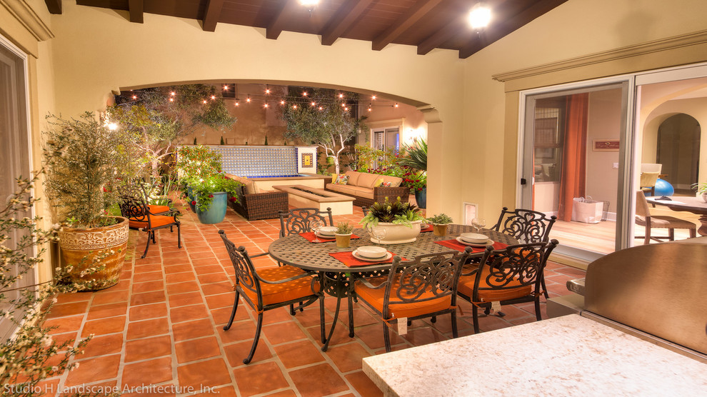 This is an example of a mid-sized mediterranean courtyard patio in Orange County with a fire feature and concrete pavers.