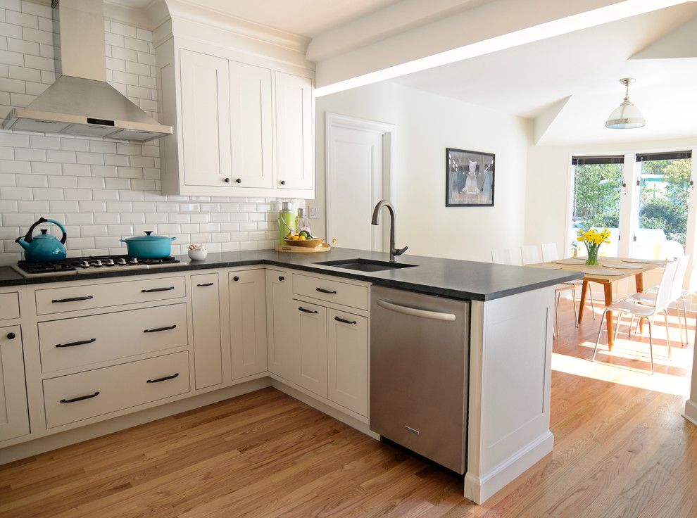 Inspiration for a small traditional u-shaped eat-in kitchen in New York with an undermount sink, shaker cabinets, beige cabinets, granite benchtops, white splashback, ceramic splashback, stainless steel appliances and a peninsula.