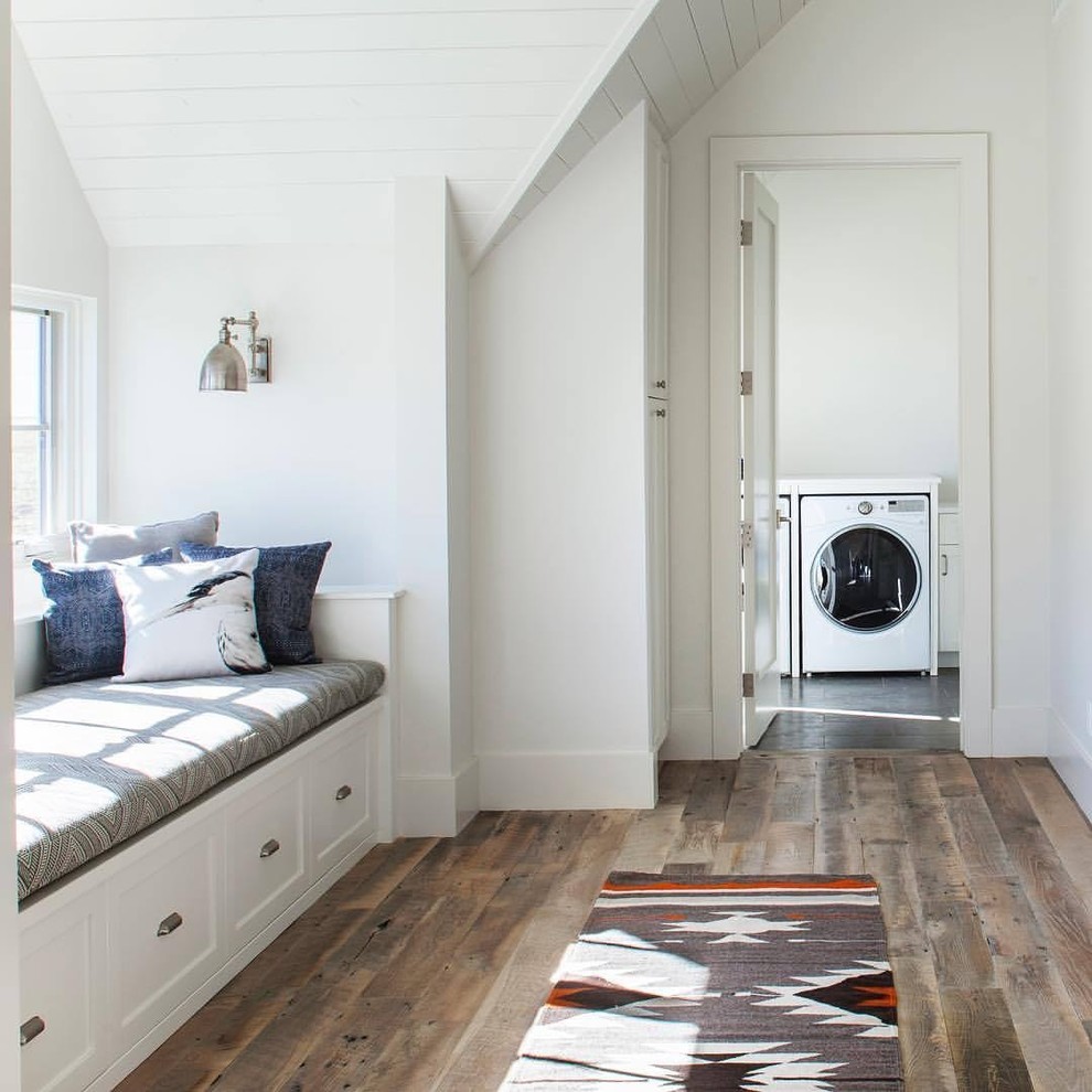 Country dedicated laundry room in Denver with white walls, medium hardwood floors, a side-by-side washer and dryer and brown floor.