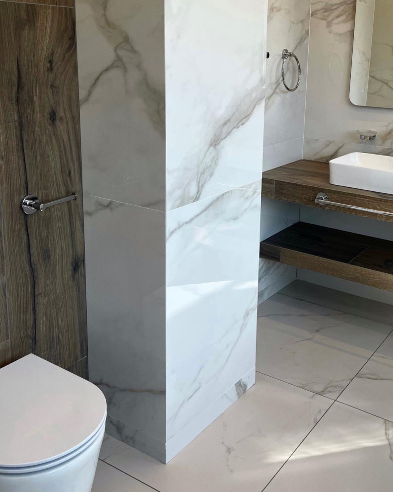 Inredning av ett minimalistiskt mellanstort en-suite badrum, med öppna hyllor, skåp i mörkt trä, en vägghängd toalettstol, flerfärgad kakel, flerfärgade väggar, klinkergolv i porslin, ett undermonterad handfat och vitt golv