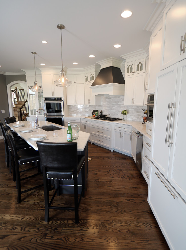 Large transitional u-shaped dark wood floor open concept kitchen photo in Cincinnati with a single-bowl sink, flat-panel cabinets, white cabinets, granite countertops, gray backsplash, subway tile backsplash, paneled appliances and an island