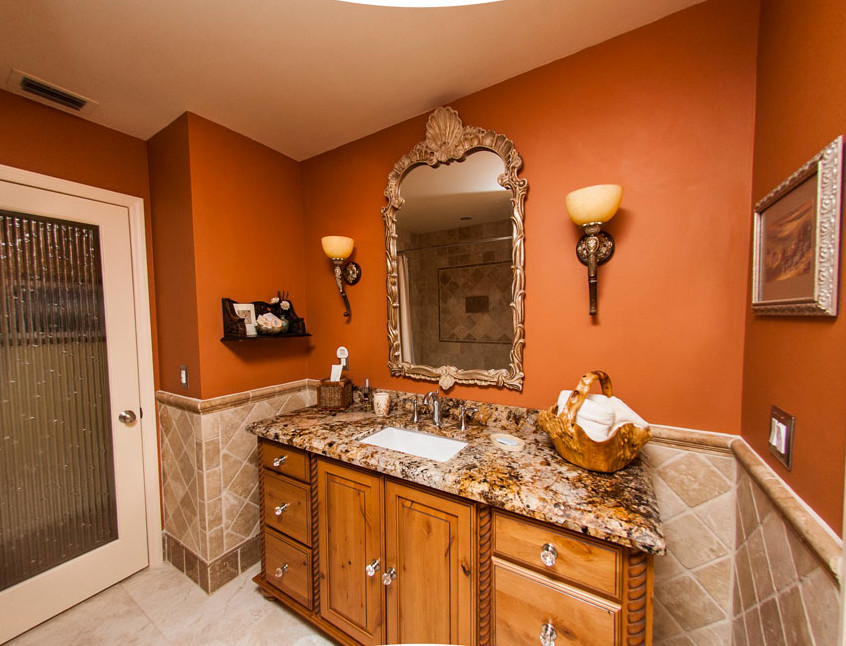 Example of a mid-sized transitional master beige tile and ceramic tile ceramic tile bathroom design in Miami with furniture-like cabinets, medium tone wood cabinets, orange walls, an undermount sink and granite countertops