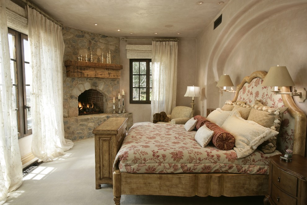 This is an example of a country bedroom in Phoenix with a corner fireplace and a stone fireplace surround.