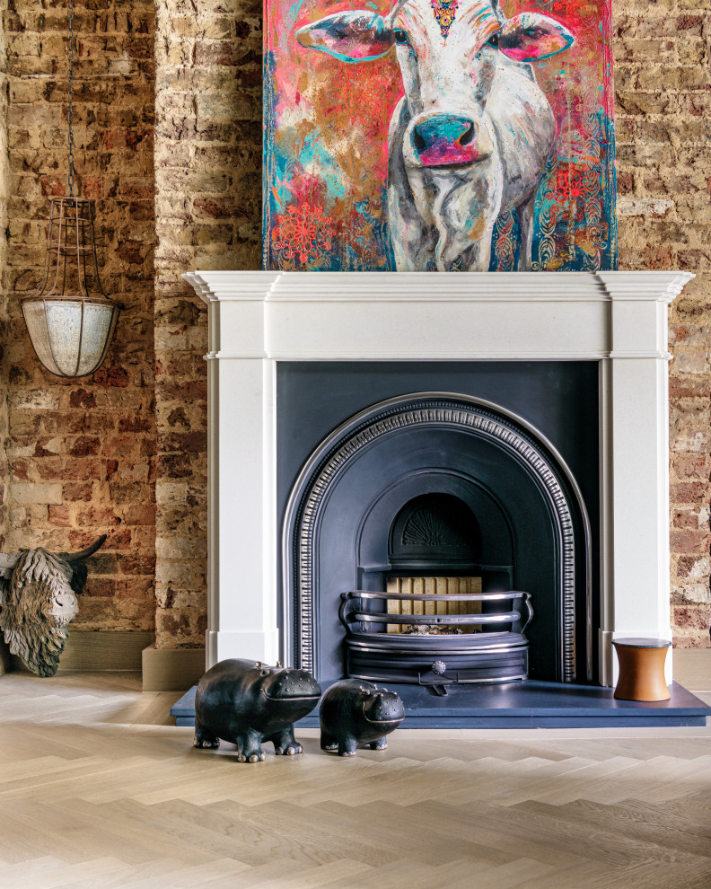 ロンドンにあるラグジュアリーな中くらいなコンテンポラリースタイルのおしゃれな書斎 (グレーの壁、レンガの暖炉まわり、グレーの床、レンガ壁、標準型暖炉、自立型机) の写真
