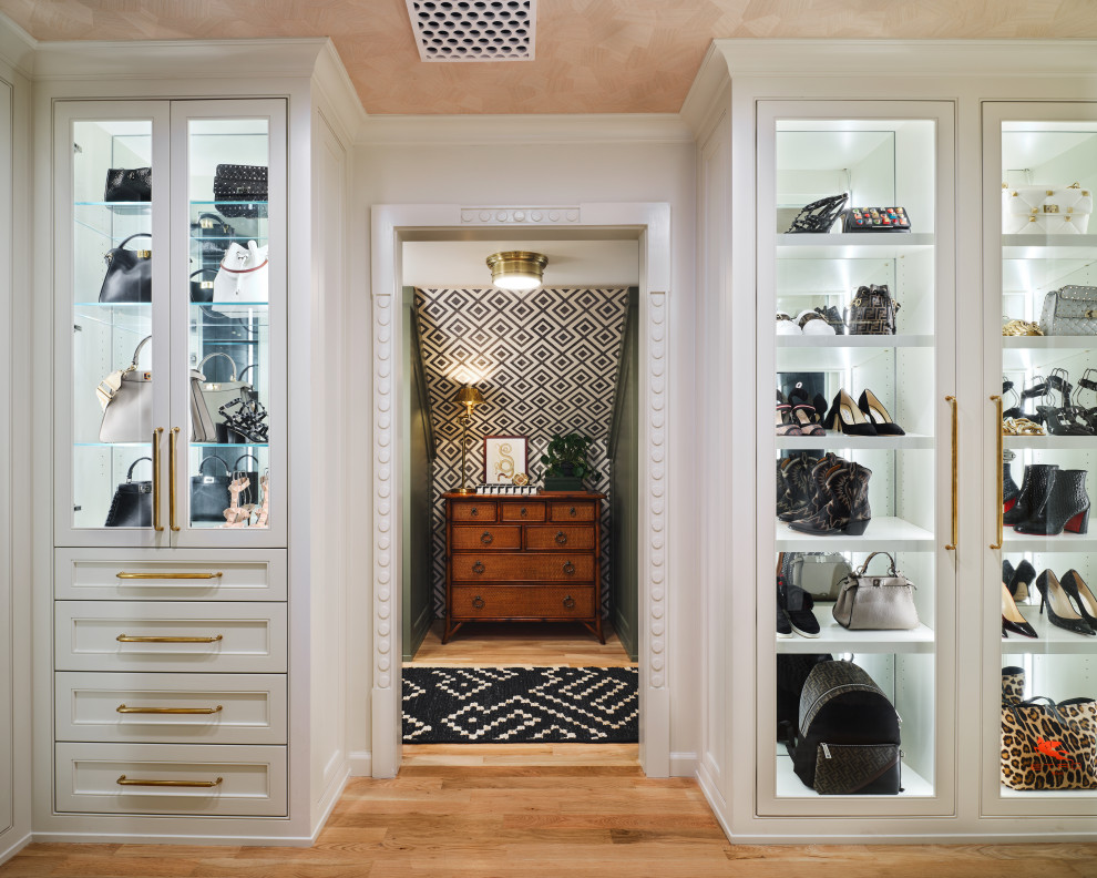Diseño de armario vestidor unisex tradicional renovado de tamaño medio con armarios con rebordes decorativos, puertas de armario blancas, suelo de madera clara y suelo beige