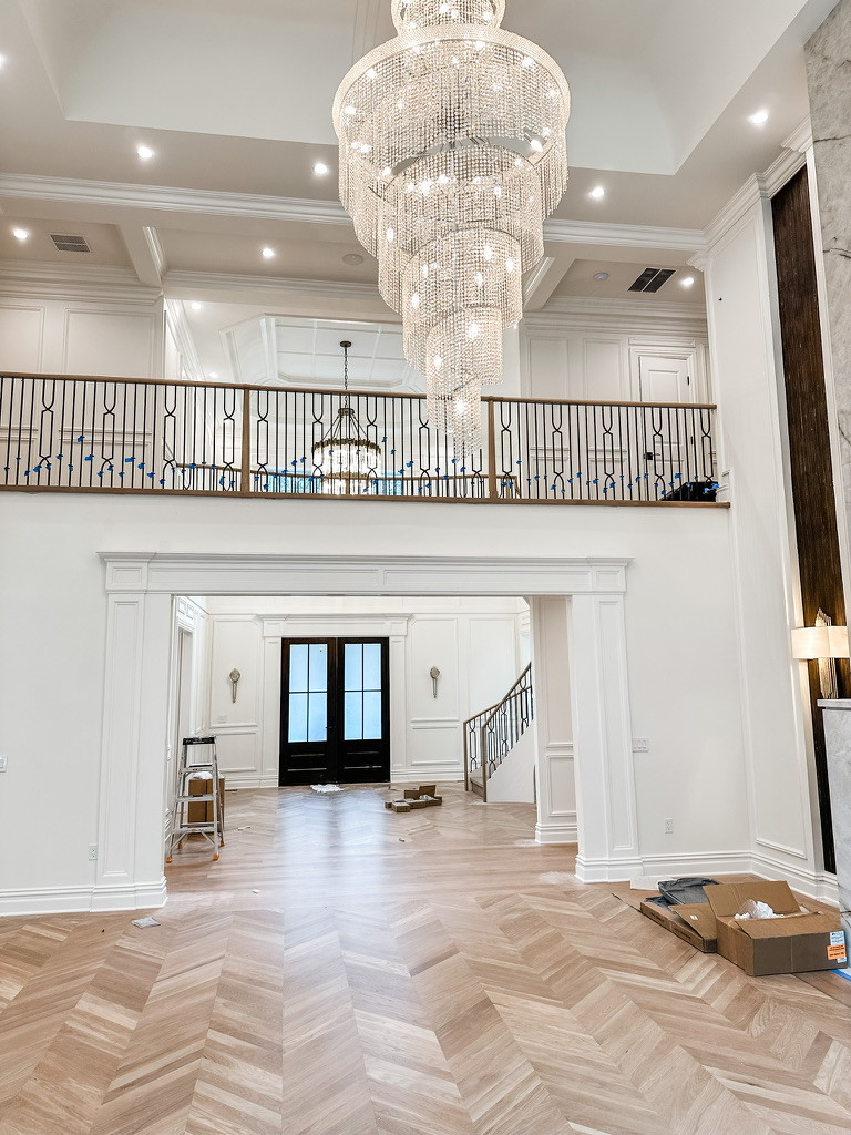 Inspiration for a large modern medium tone wood floor, brown floor and vaulted ceiling foyer remodel in New York with white walls
