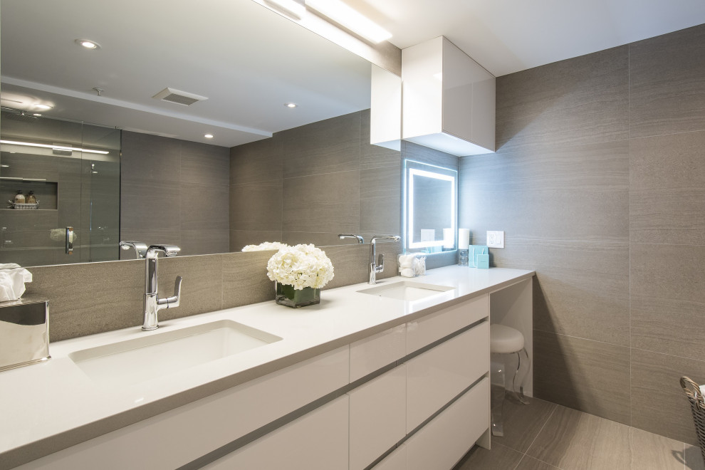 Photo of a mid-sized contemporary master bathroom in Vancouver with flat-panel cabinets, white cabinets, porcelain tile, porcelain floors, an undermount sink, engineered quartz benchtops, white benchtops, a freestanding vanity, panelled walls, brown tile, brown walls, beige floor, a niche and a double vanity.