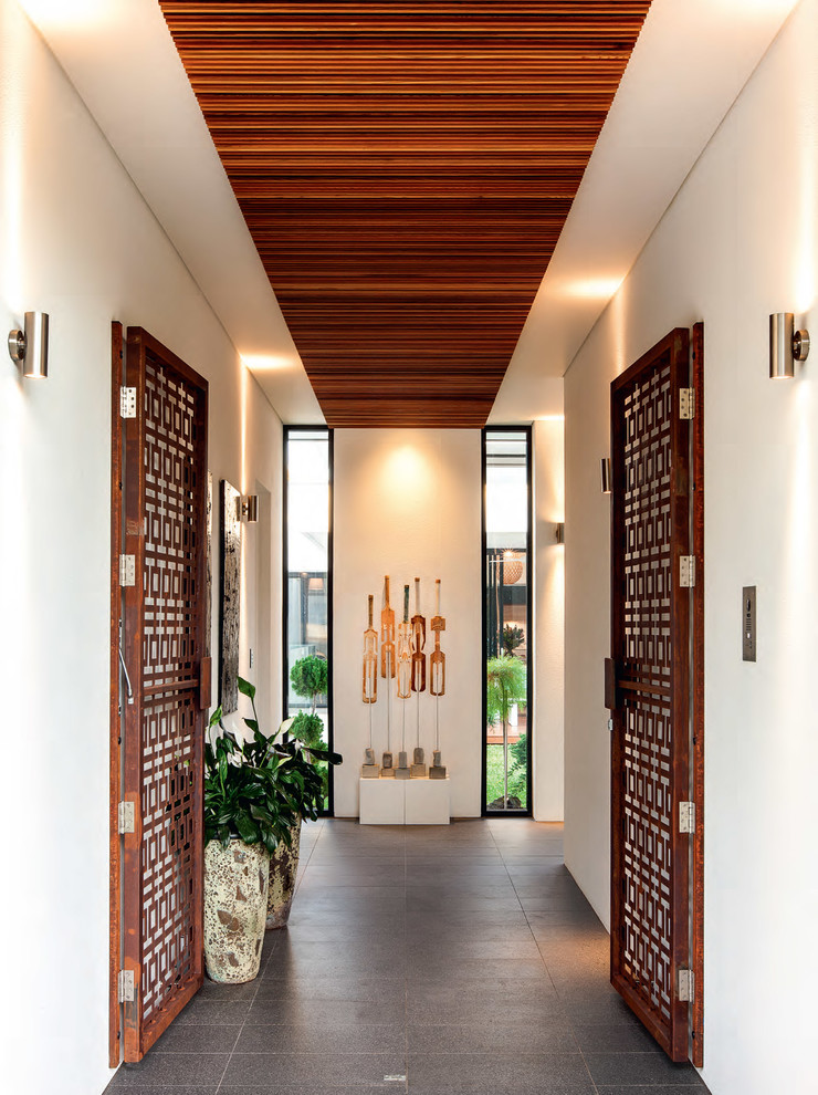 This is an example of a contemporary vestibule in Adelaide with white walls, porcelain floors, a double front door and a metal front door.