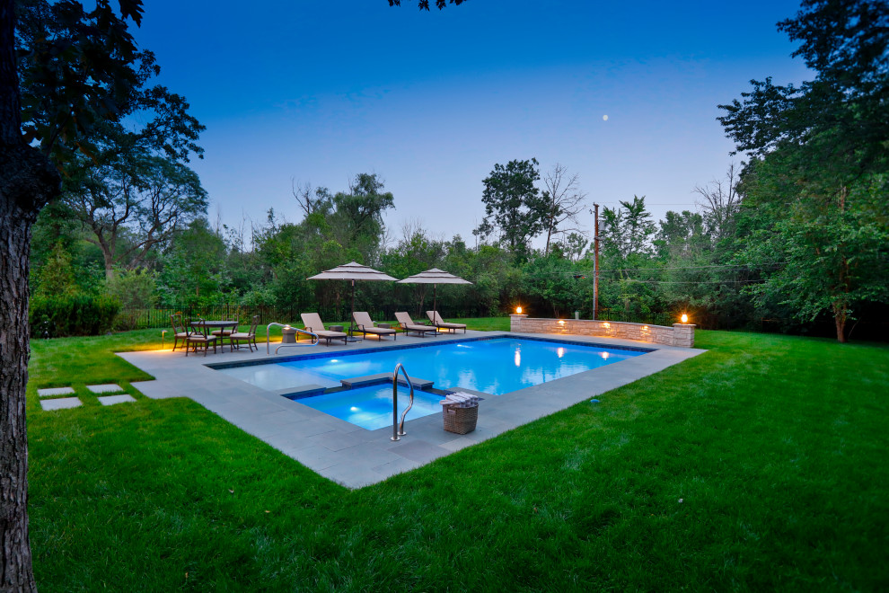 Foto de piscina alargada tradicional de tamaño medio rectangular en patio trasero con privacidad y adoquines de piedra natural