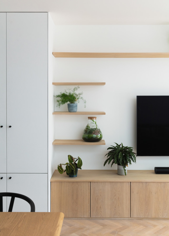 Idées déco pour un salon contemporain ouvert avec un mur blanc, un sol en bois brun et un téléviseur fixé au mur.