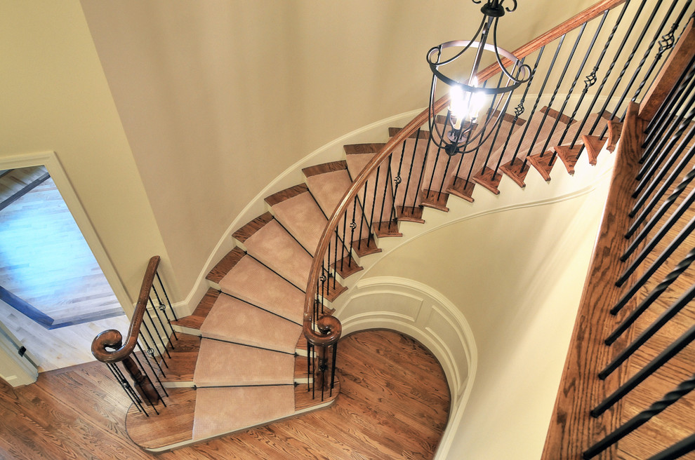 Mid-sized traditional wood spiral staircase in Charlotte with painted wood risers.