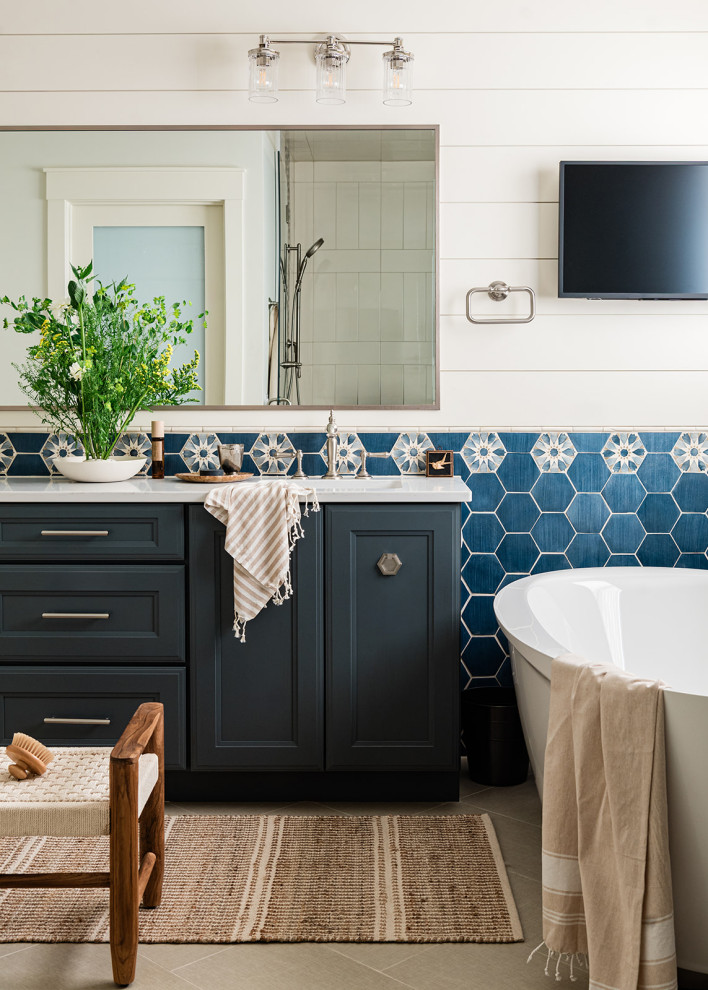 Идея дизайна: ванная комната в стиле неоклассика (современная классика) с керамической плиткой, полом из керамогранита, фасадами с утопленной филенкой, черными фасадами, отдельно стоящей ванной, синей плиткой, белыми стенами, врезной раковиной, серым полом, белой столешницей, тумбой под две раковины и стенами из вагонки
