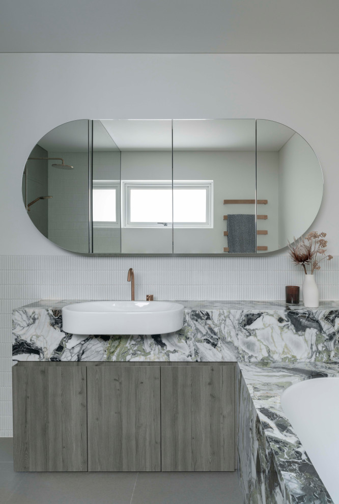 Inspiration for an expansive contemporary bathroom in Sydney with flat-panel cabinets, medium wood cabinets, a drop-in tub, green tile, ceramic tile, ceramic floors, a vessel sink, marble benchtops, grey floor, green benchtops, a single vanity and a floating vanity.